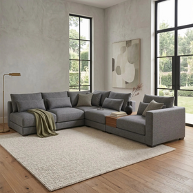 Gray sectional sofa in a modern living room with large windows.