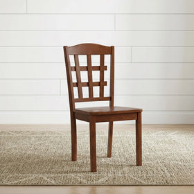 Wooden chair with lattice back design on a beige rug and white wall background