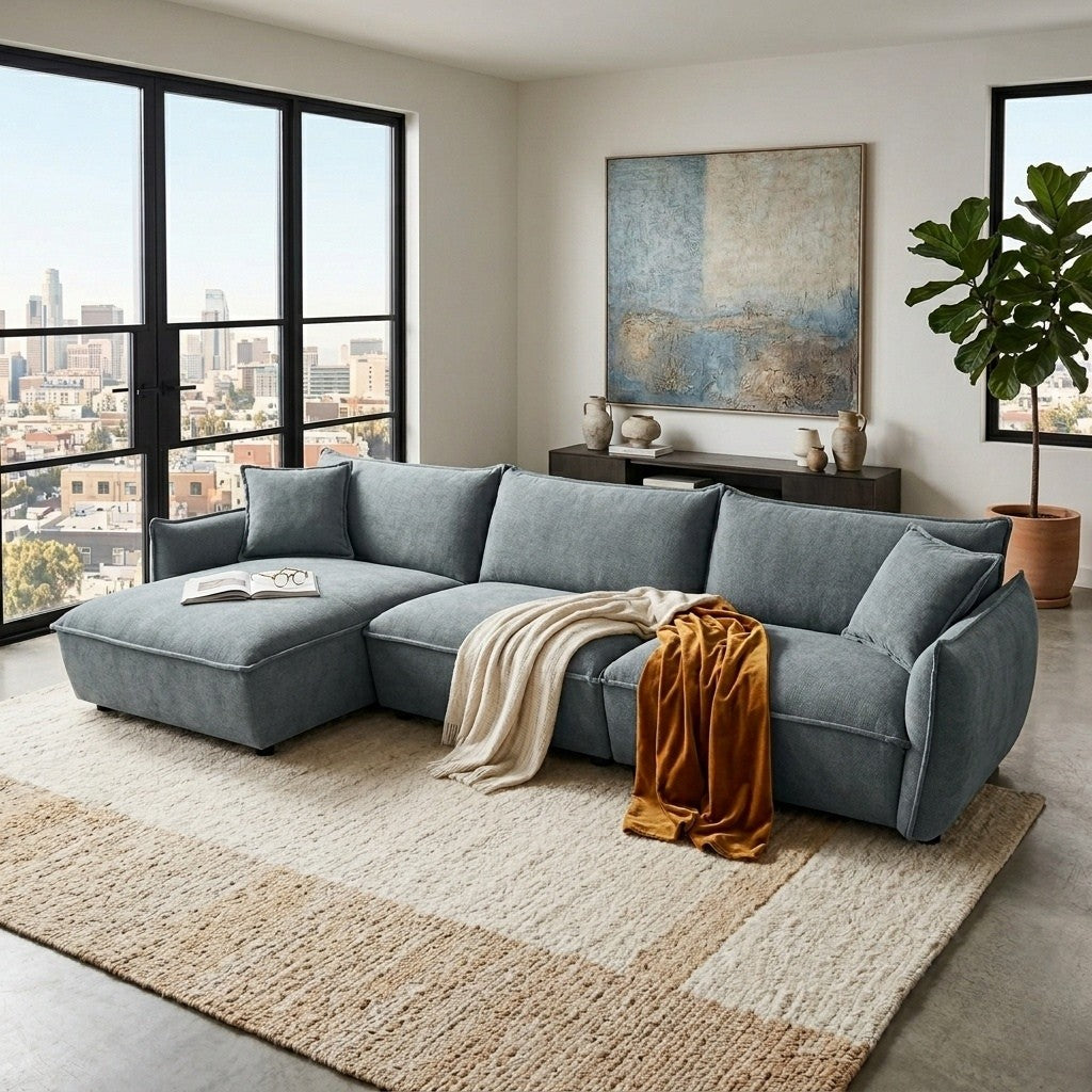Gray sectional sofa in a modern living room with large windows and cityscape view.