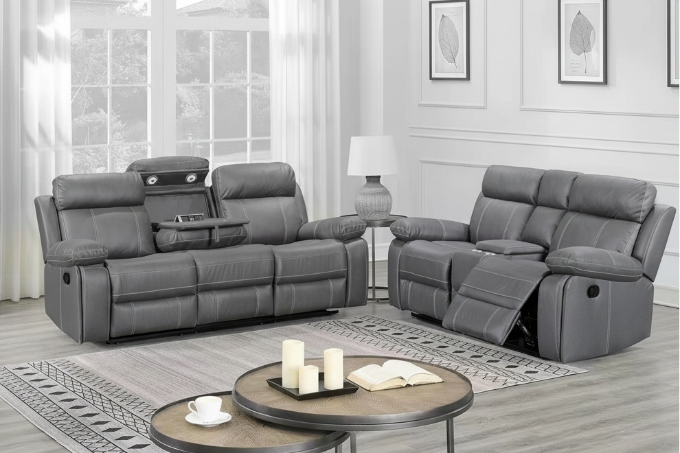 Grey fabric reclining sofa set in a living room with a coffee table and candles.