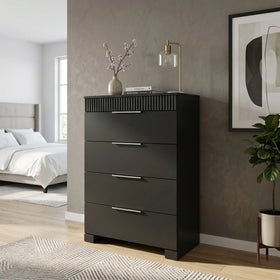 Black tallboy with four drawers in a bedroom setting.