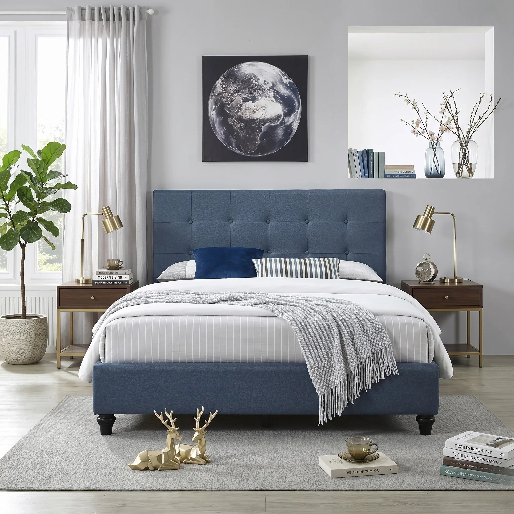 Modern bedroom featuring the Franco bed with a blue upholstered headboard and frame, flanked by wooden side tables with brass lamps, decorated with plush bedding and stylish accents.