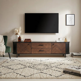 Wooden TV stand with a television mounted on a wall in a living room setting.