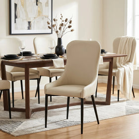 Dwayne Chair in cream upholstery with dark tapered legs, set with matching chairs around a timber dining table in a bright room