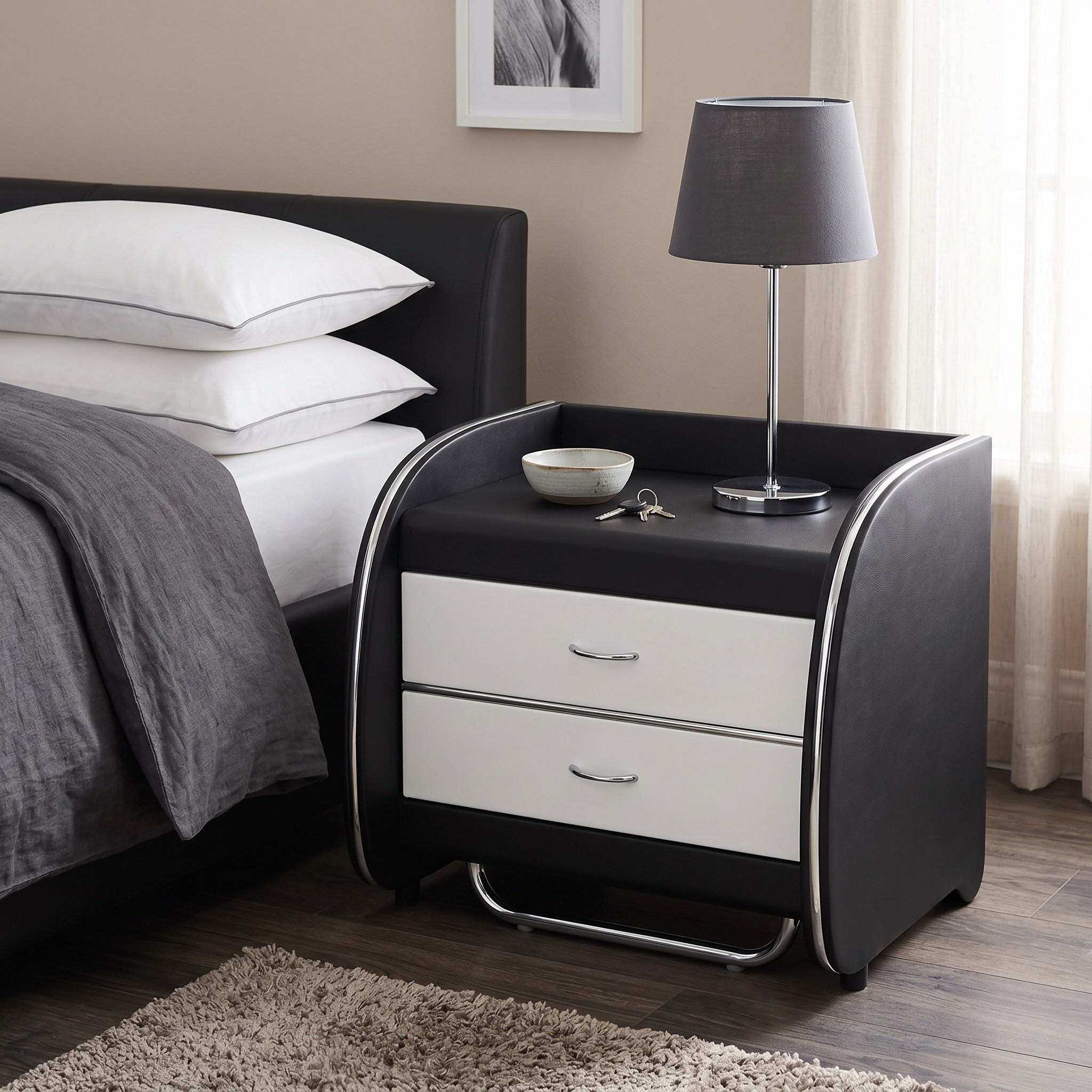 Black nightstand with white drawers next to a bed with white pillows and gray bedding.