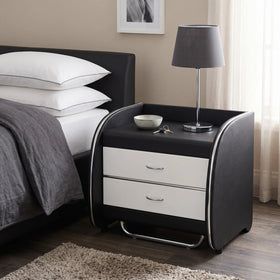 Black nightstand with white drawers next to a bed with white pillows and gray bedding.