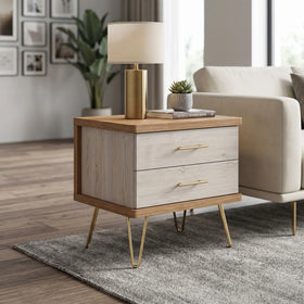 Mildura End Table with light wood finish, two drawers with brass handles, sleek brass hairpin legs, styled with a modern gold table lamp and small plant on top, next to a beige sofa.