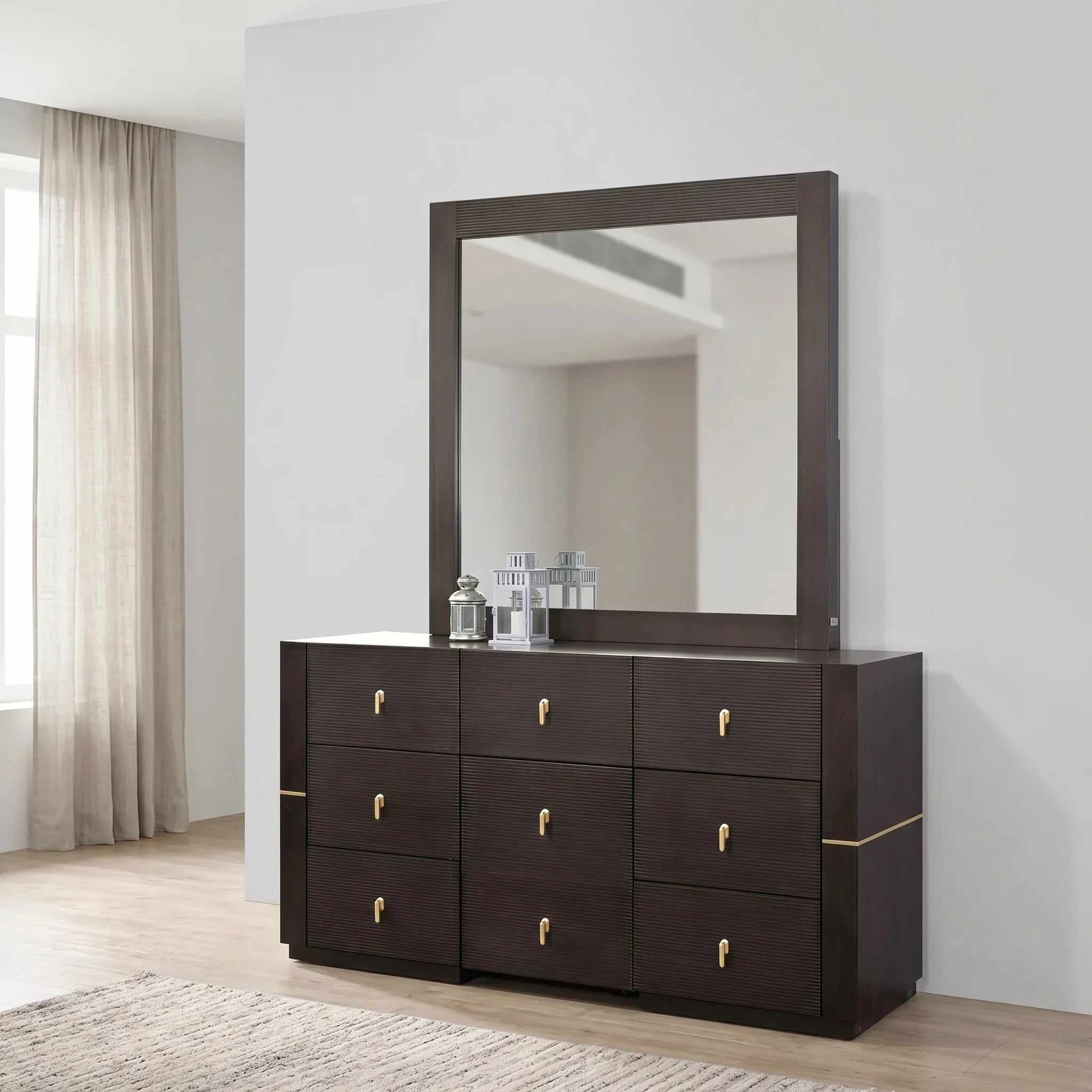 Dark wood dresser with a large mirror in a room with light-colored curtains and flooring.
