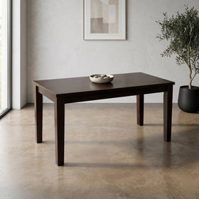 Dark wooden table in a modern room with a plant and abstract art on the wall.