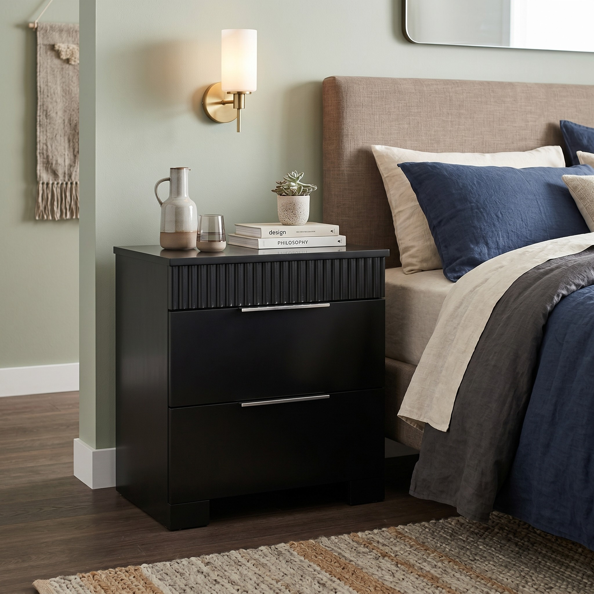 Black nightstand with decorative items next to a bed with blue and beige bedding.