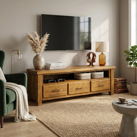 Living room with wooden TV stand, green armchair, and decorative items.