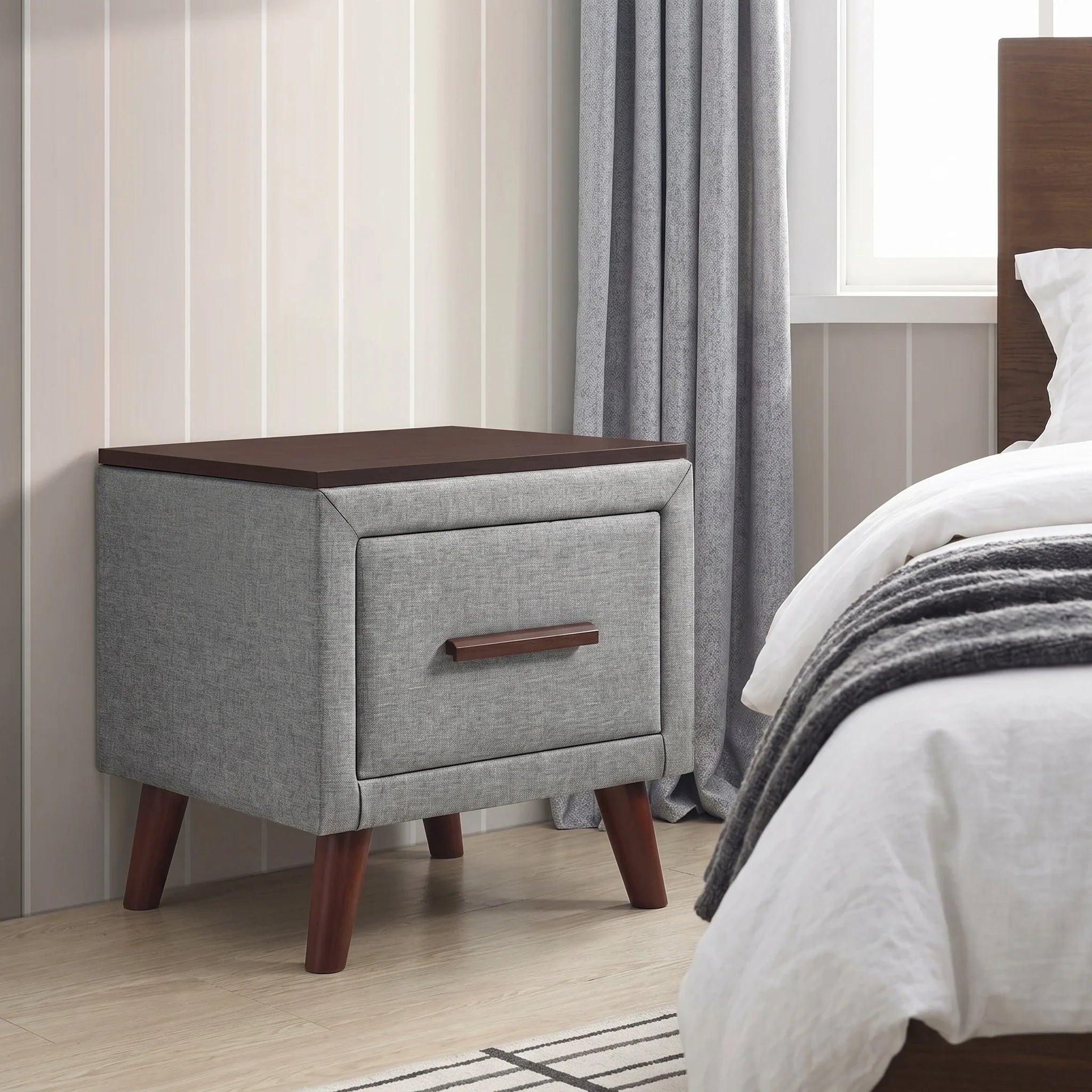 Gray nightstand with wooden top and legs in a bedroom setting