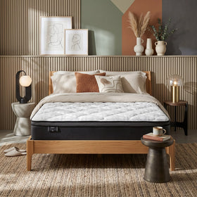 Bedroom with a bed featuring a mattress, pillows, and a wooden headboard.