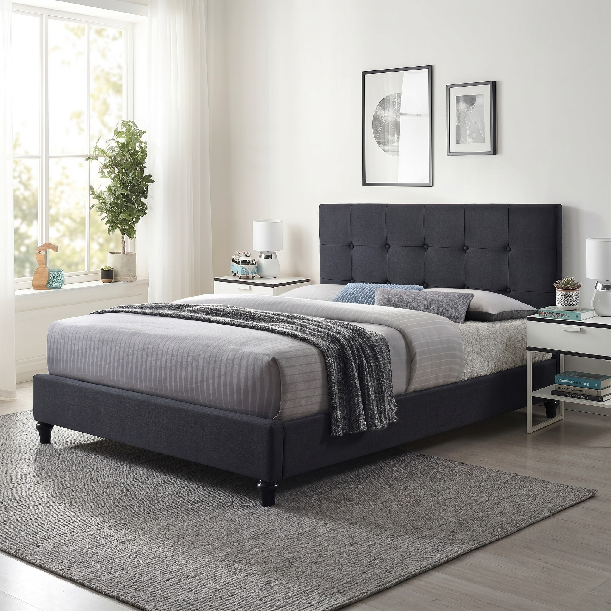 Franco modern bed frame with upholstered dark grey fabric, button-tufted headboard, neatly made bed with gray bedding, throw blanket, and decorative pillows in a bright, minimalist bedroom.
