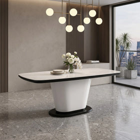 Modern dining table with a white base and black top in a stylish room with large windows.