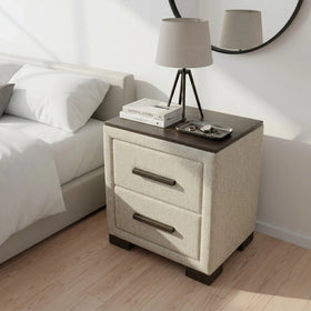 Beige nightstand with two drawers next to a bed in a bedroom setting.
