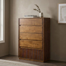 Wooden dresser with three drawers in a room with a window and framed picture on the wall.