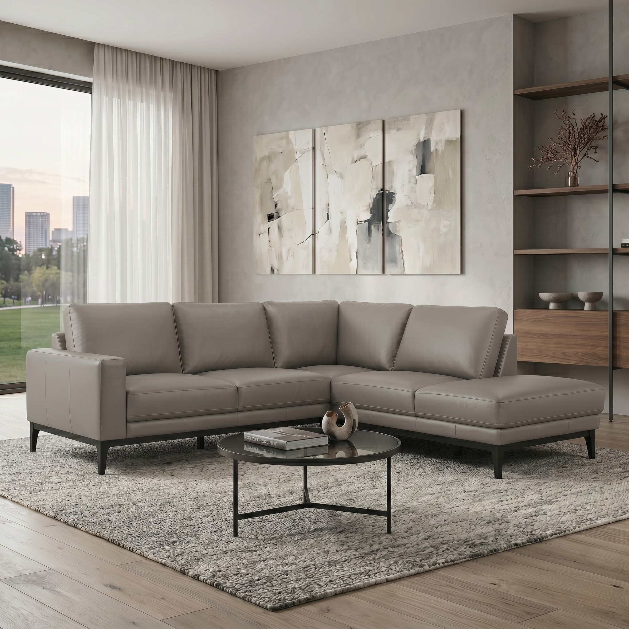 Modern living room with a gray sectional sofa, round coffee table, and abstract art on the wall.