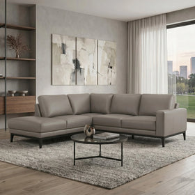 Modern living room with a gray sectional sofa, coffee table, and abstract wall art.
