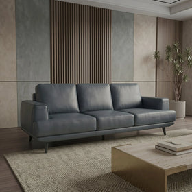 Anthracite sofa in a modern living room with a wooden coffee table and decorative plants.
