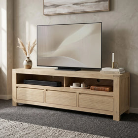 Wooden TV stand with a television and decorative items in a living room.