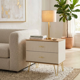 White nightstand with gold legs next to a beige sofa in a living room.