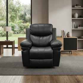 Sutton Rocker Recliner Chair in black leather, featuring plush cushioned armrests and backrest, placed in a modern living room with natural light and minimal decor.