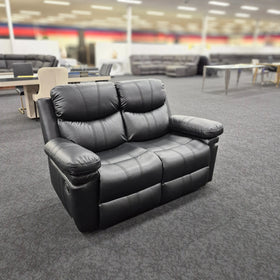 Black leather 2 seater recliner lounge in a modern furniture showroom setting