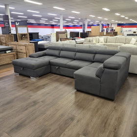 Alex Pull Out Sofa Bed in dark grey fabric, angled view from the left showing the storage chaise and corner seat, in The A2Z Furniture showroom