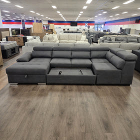Alex Pull Out Sofa Bed in dark grey fabric, pulled out flat into the bed in The A2Z Furniture showroom