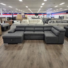 Alex Pull Out Sofa Bed in dark grey fabric, front-on view with adjustable headrests and chaise ends at both sides, in The A2Z Furniture showroom