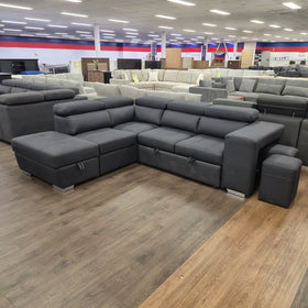 Alice Sofa Bed in black fabric, angled view from the chaise end showing the corner seat and adjustable headrests, in The A2Z Furniture showroom