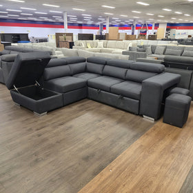 Alice Sofa Bed in black fabric with the chaise lid lifted on gas struts to show the empty storage compartment, in The A2Z Furniture showroom