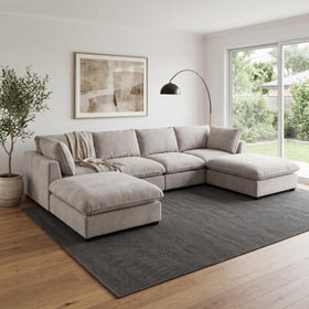 Aspley 6 Piece Modular Lounge in Light Grey arranged as a U-shape with two ottomans in a living room with garden view