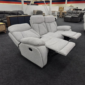 Baker 3 seater recliner lounge in light grey fabric on the floor of The A2Z Furniture showroom with two footrests extended, showing the reclining mechanism