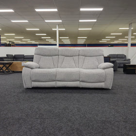 Baker 3 seater recliner lounge in light grey fabric seen front on in The A2Z Furniture showroom, showing three seat cushions and padded scatter armrests