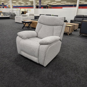 Baker recliner chair in light grey fabric standing upright in The A2Z Furniture showroom, viewed at an angle showing the padded armrests and high back