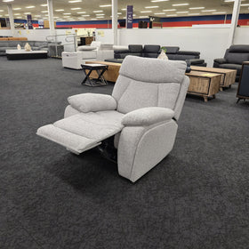 Baker recliner chair in light grey fabric in The A2Z Furniture showroom with the footrest extended, viewed at an angle