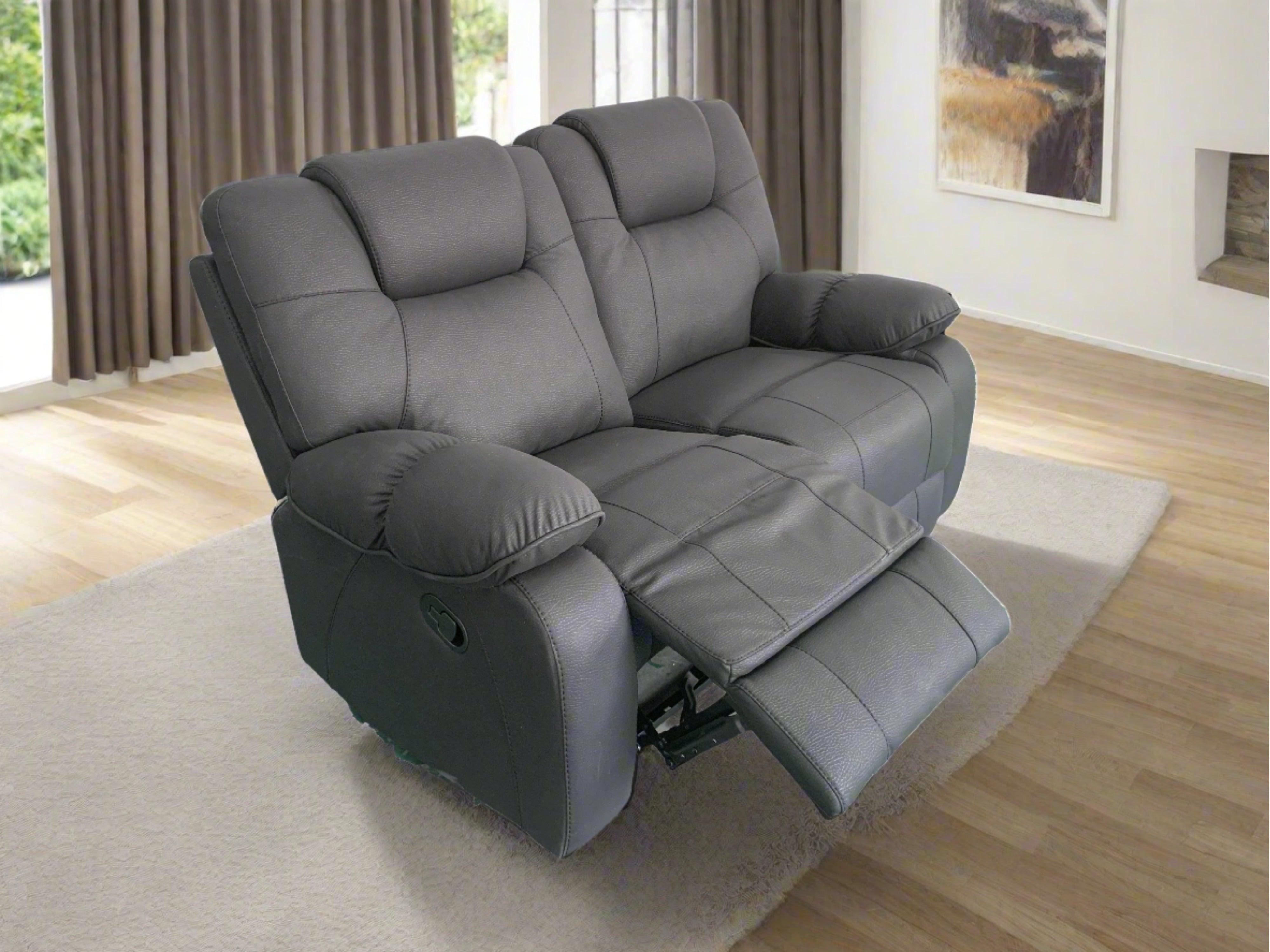 Grey two-seater recliner sofa in a modern living room on a light rug