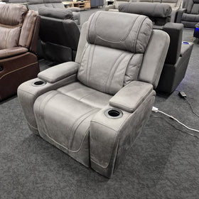 Ballina Electric Recliner Chair in grey seen from a front three-quarter angle, showing the padded headrest and both arm cup holders, in The A2Z Furniture showroom