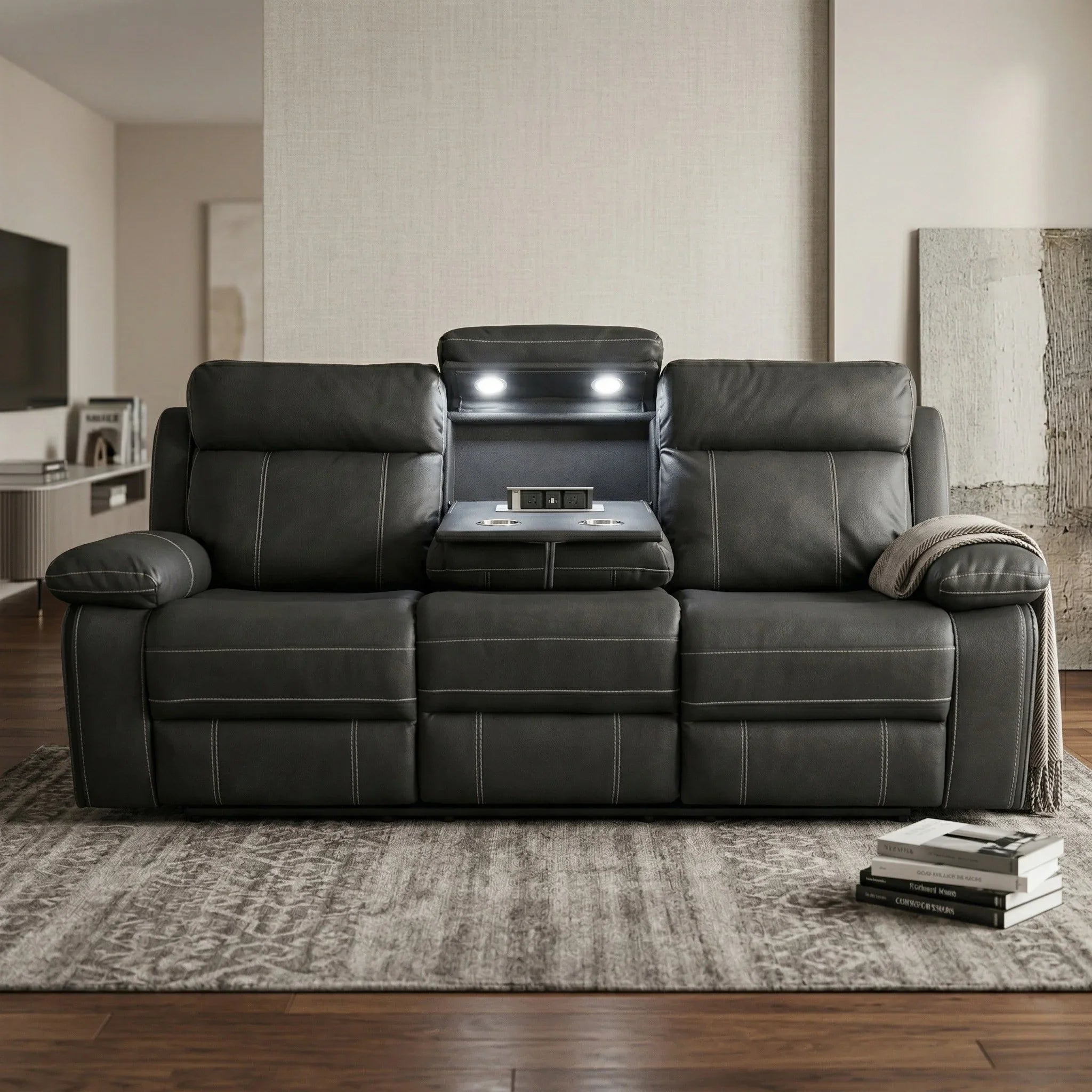 Black fabric sofa in a living room setting with books and a blanket.