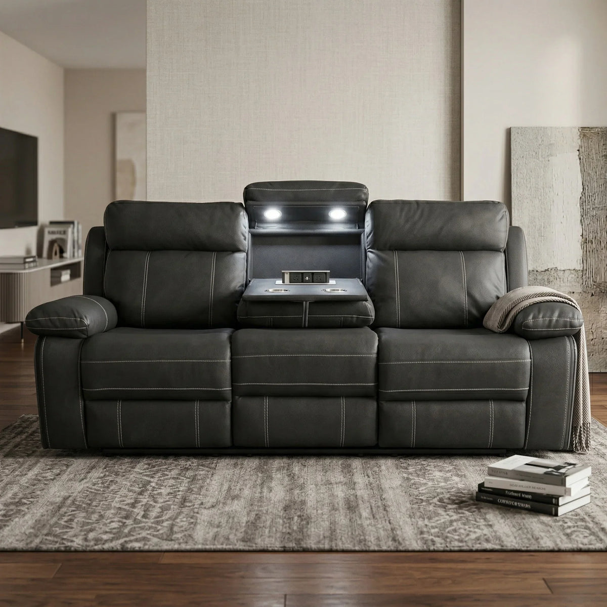 Black fabric sofa in a living room setting with books and a blanket.