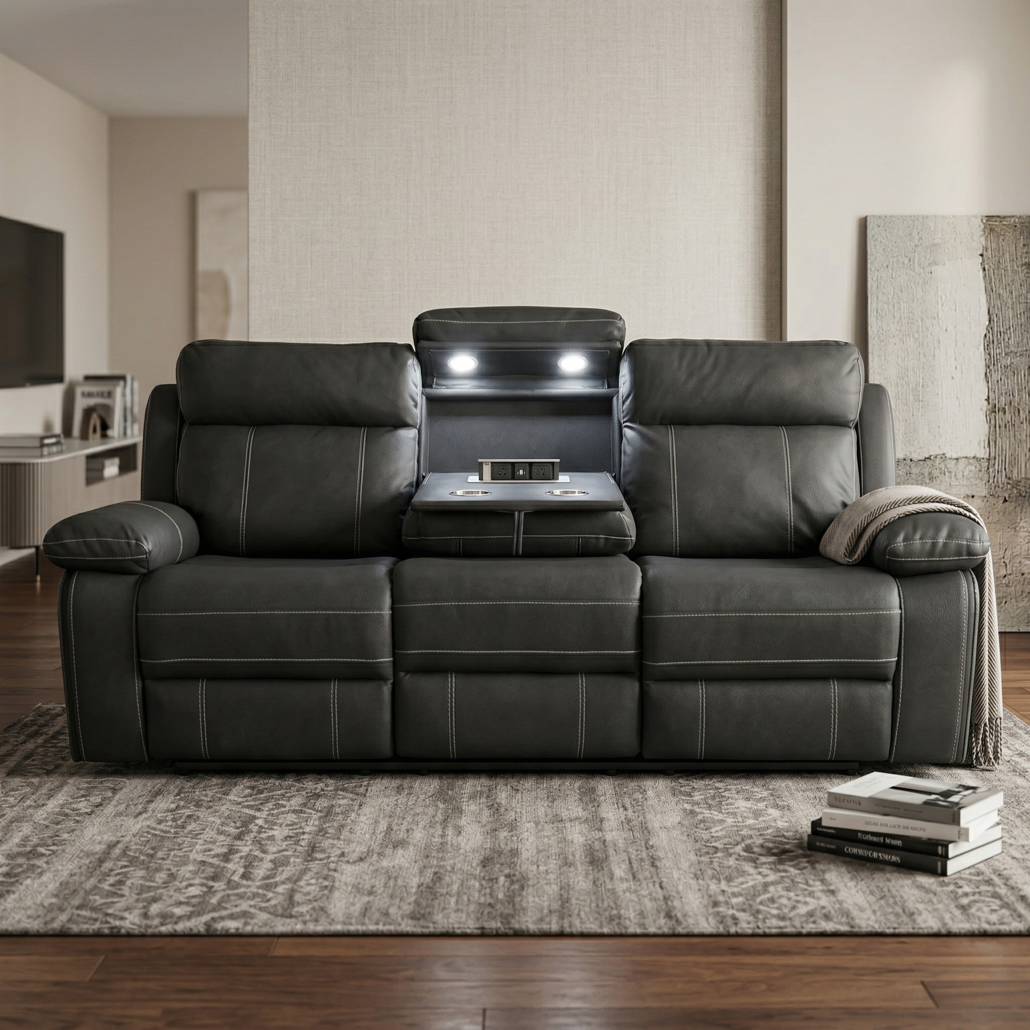 Black fabric sofa in a living room setting with books and a blanket.