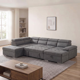 Alex Pull Out Sofa Bed in dark grey fabric, chaise on the right and storage ottoman on the left beside the sofa, with adjustable headrests, in a bright living room