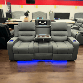 Charcoal three seater recliner sofa with cup holders, LED lighting, fold-down tray, and reading lights on showroom floor.