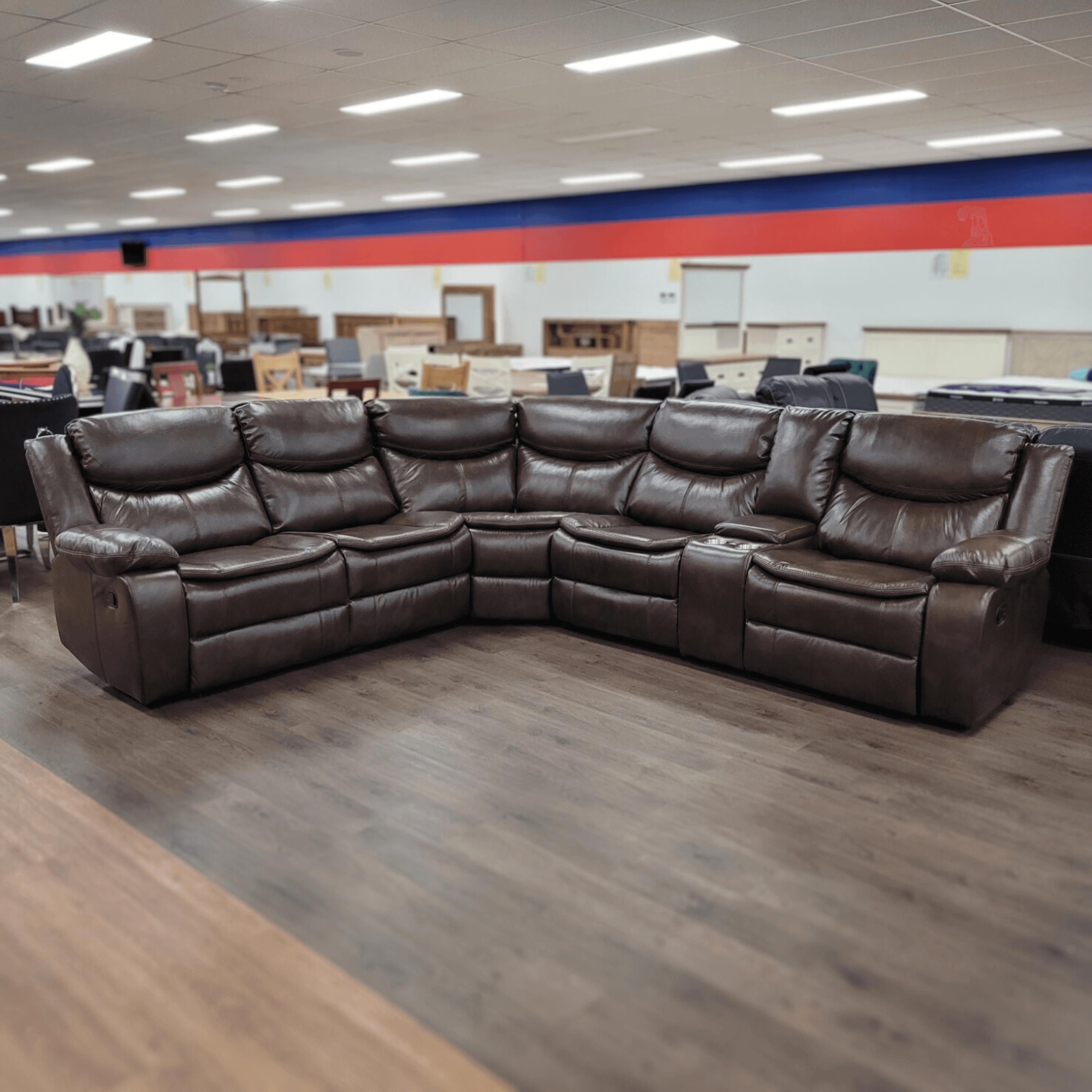 Large brown leather sectional reclining sofa displayed in a furniture showroom