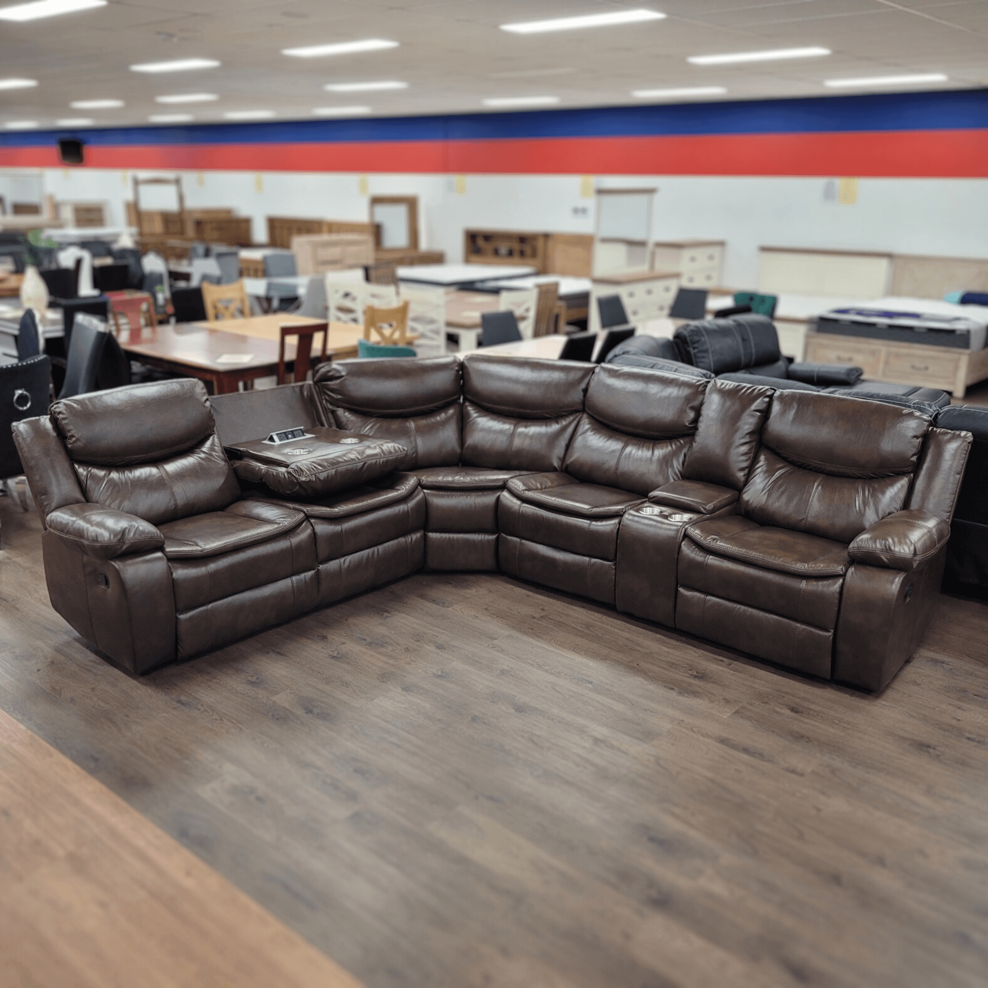 Large brown leather recliner sectional sofa with cup holders in furniture showroom