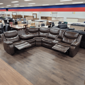 Brown leather reclining sectional sofa with cup holders in a furniture showroom