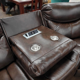 Brown leather recliner sofa with built-in cup holders and power outlets in a showroom