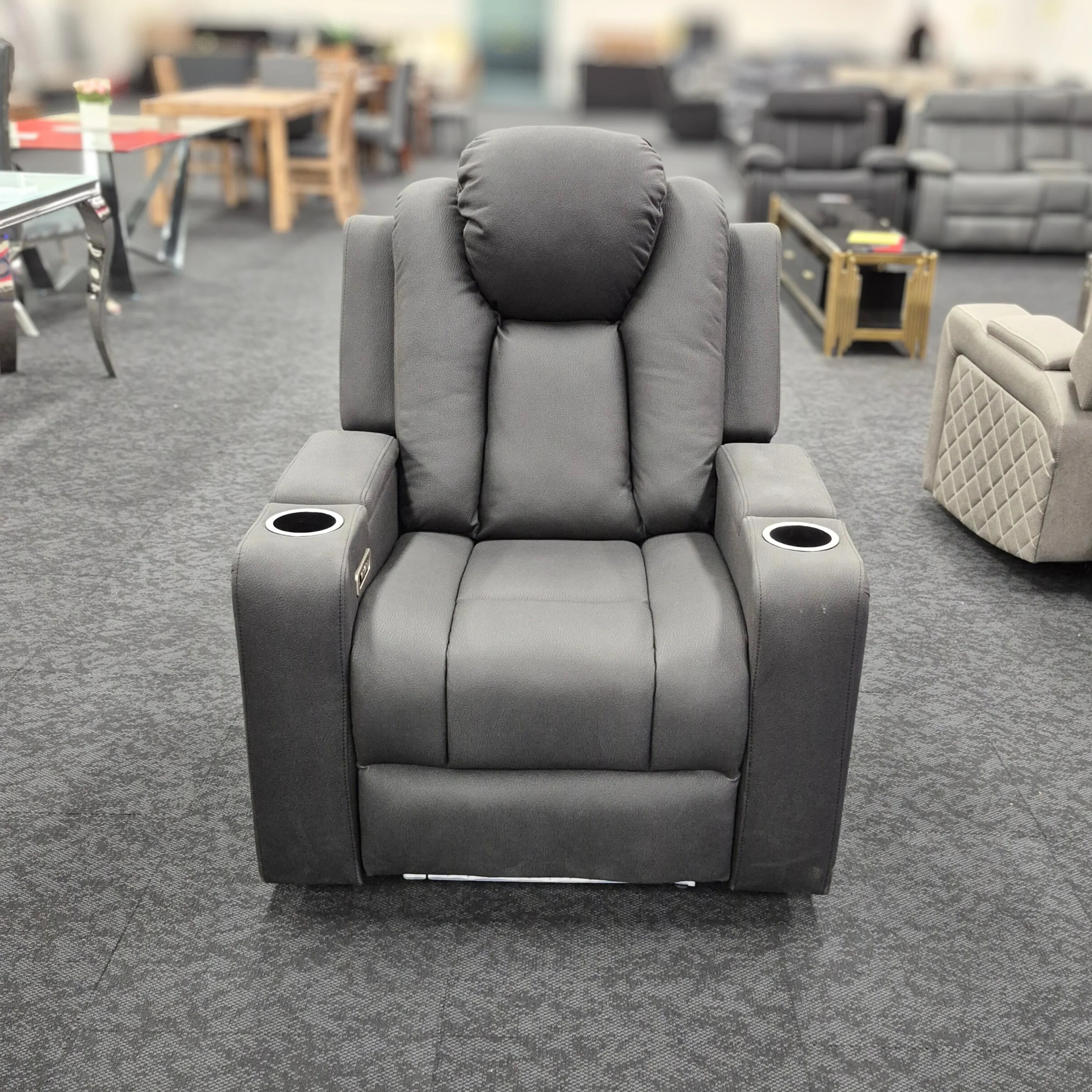 Gray dual motor electric recliner chair with cup holders in a showroom